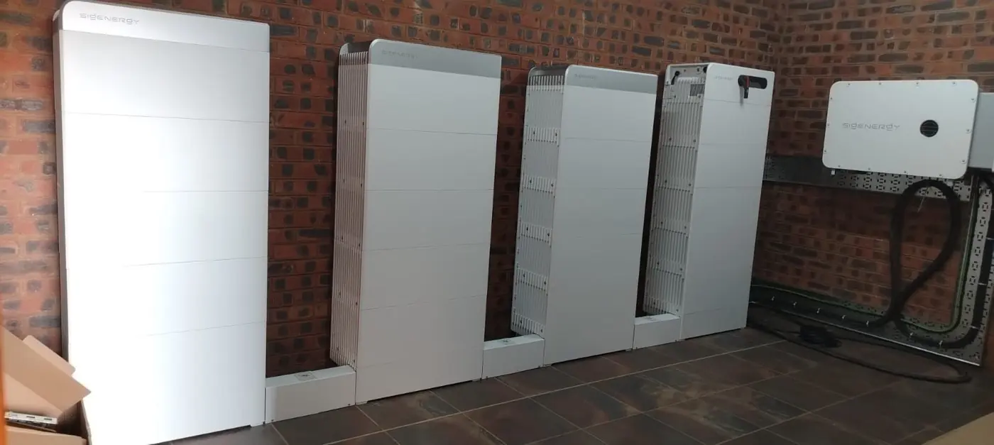 Row of Sigenergy battery stacks against a face-brick wall